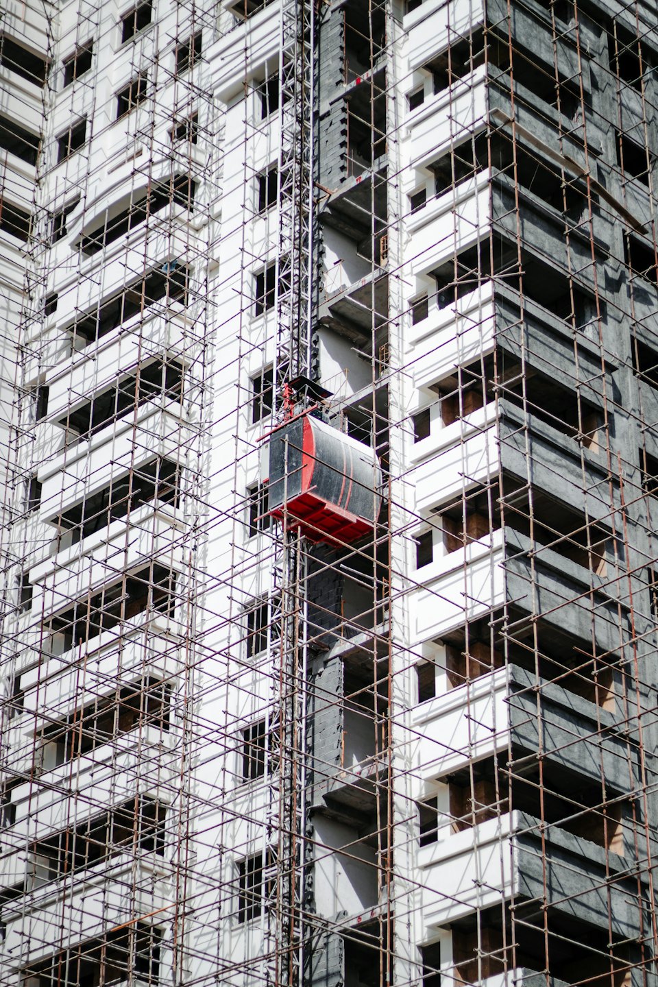 Moderno edificio in costruzione coperto da ponteggi.